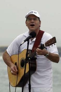 Man singing and playing guitar outdoors.