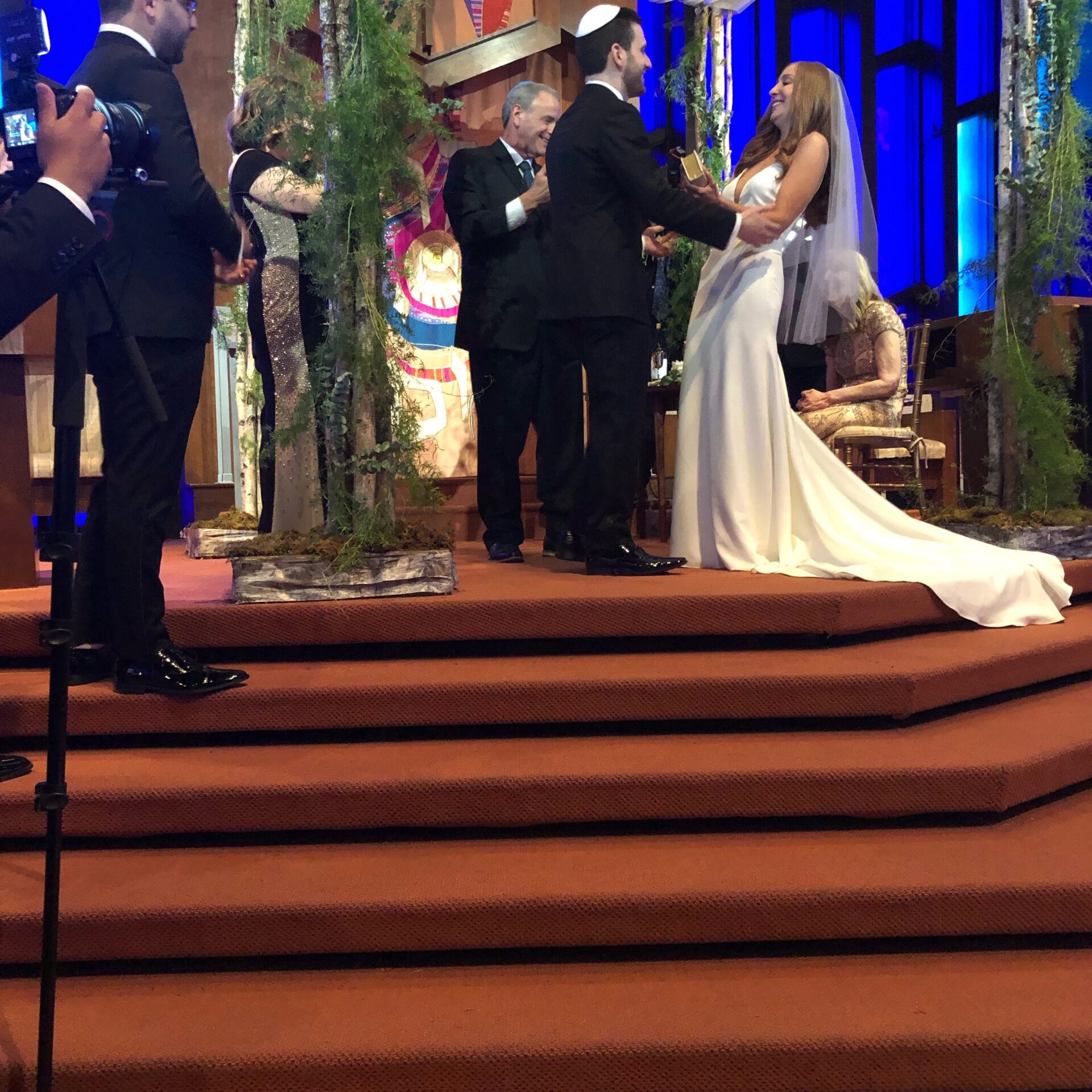 A couple exchanging vows during a wedding ceremony on stage.