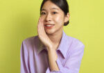 Secret Offer. Smiling Japanese Woman Whispering Holding Hand Near Mouth Looking At Camera, Spreading Gossips And Sharing Information Posing Over Yellow Background. Studio Shot